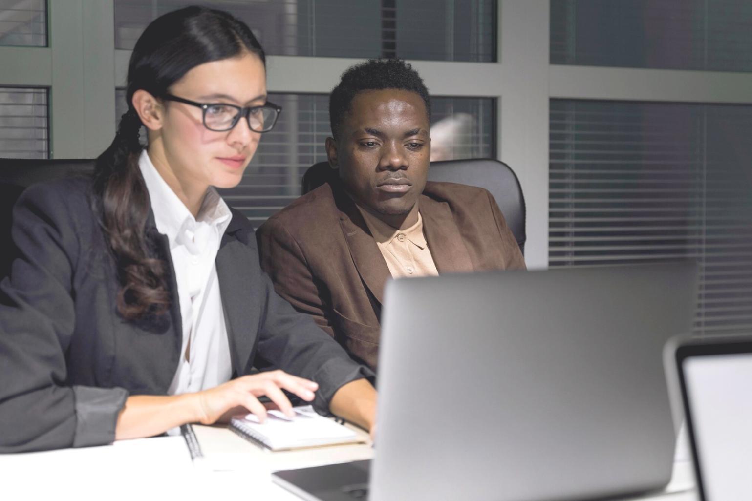 Business professionals analyzing financial data and performance metrics on computer screens
